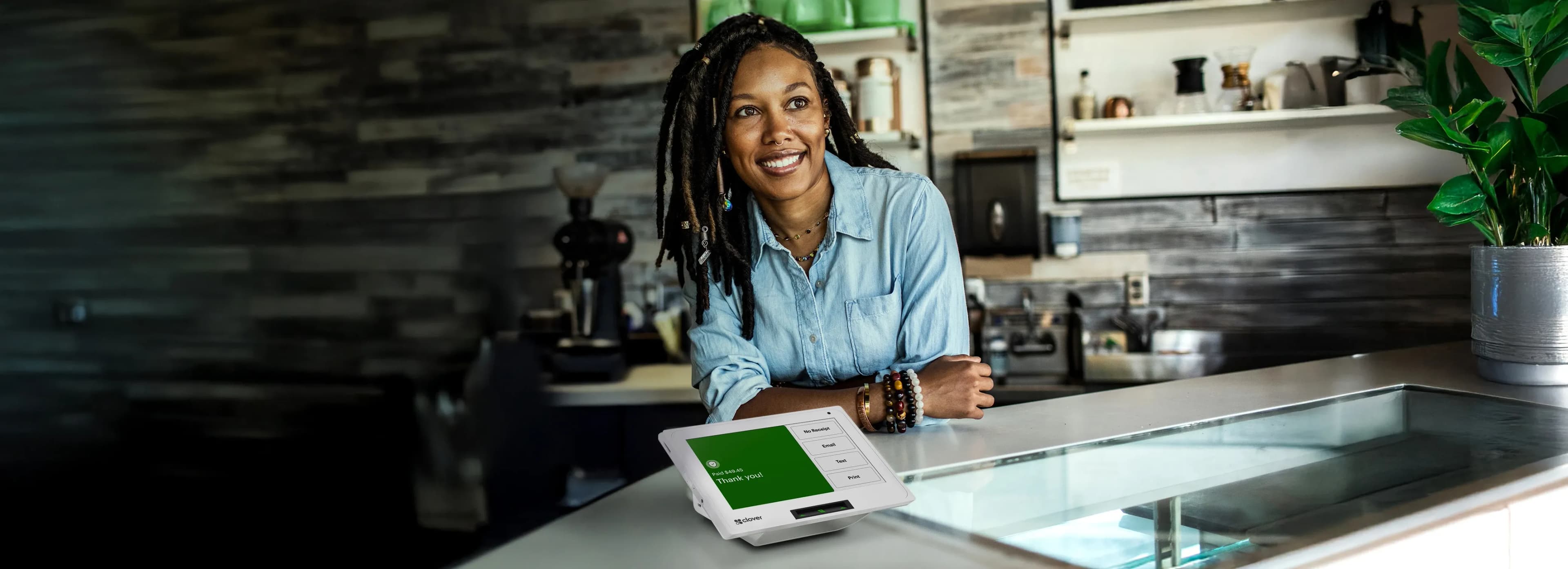 Business owner behind the counter with a Clover payment terminal