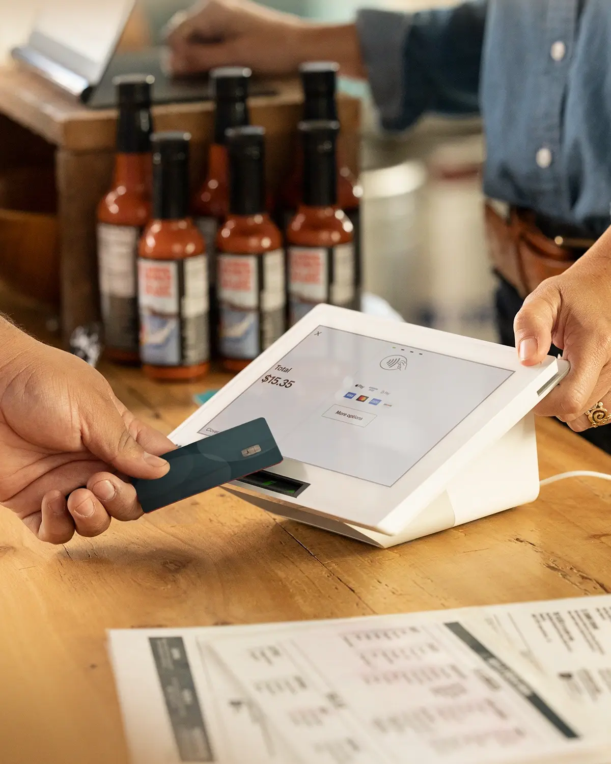 Customer inserting a payment card into a Clover Mini at a café